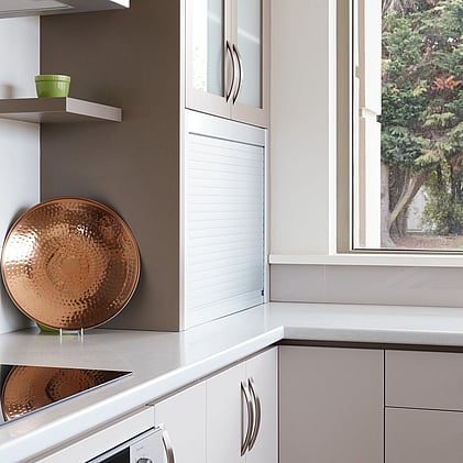 Sophisticated custom kitchen design with floating shelves and copper accents, showcased in Barrett Joinery's Timaru showroom to highlight functional yet stylish joinery solutions.