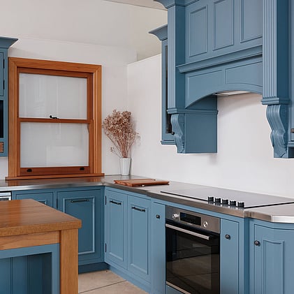 Classic blue kitchen cabinets with timber accents in a traditional kitchen display at Barrett Joinery's Timaru showroom, blending timeless style with expert joinery craftsmanship.
