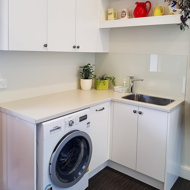 Custom laundry joinery designed for efficient use of space with stylish cabinetry and hidden storage solutions.