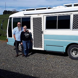 Picture of couple standing beside motorhome with security doors and security windows