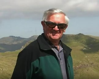 Bruce Smith wearing sunglasses with farmland behind him