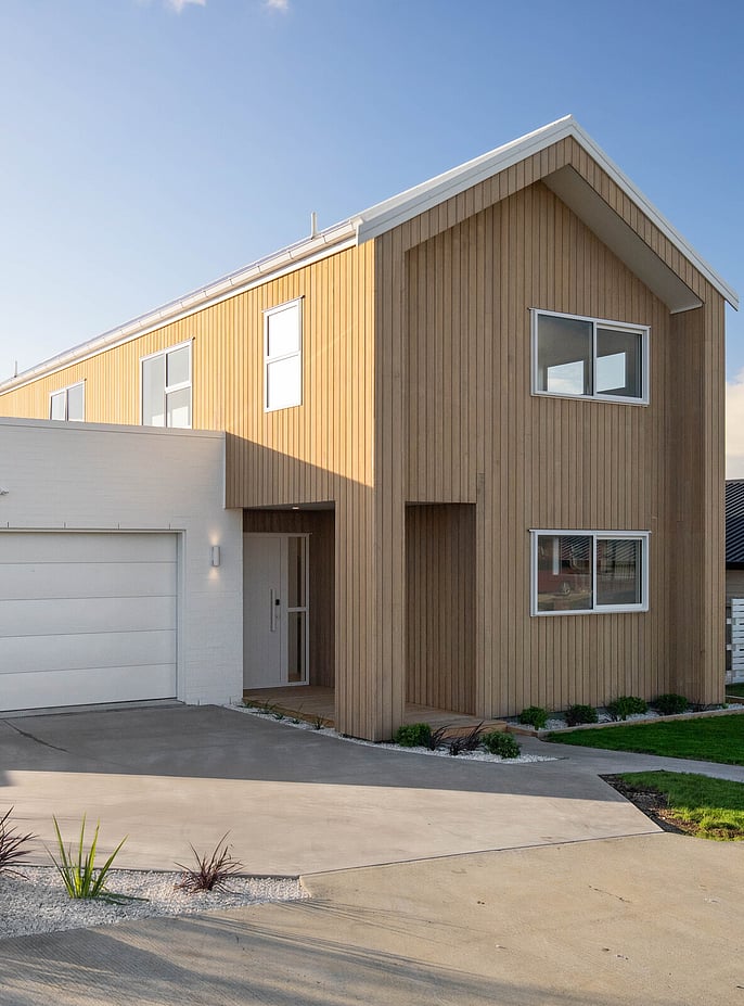 Modern two storey home with vertical timber cladding and contrasting white brick garage