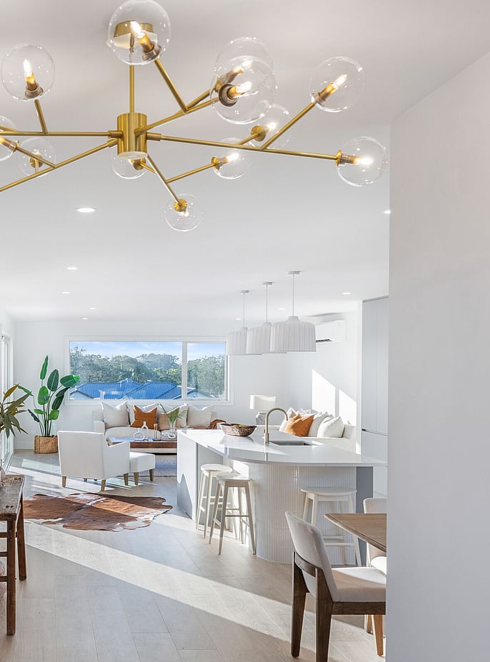 crisp white kitchen and living area with contemporary feature pendant