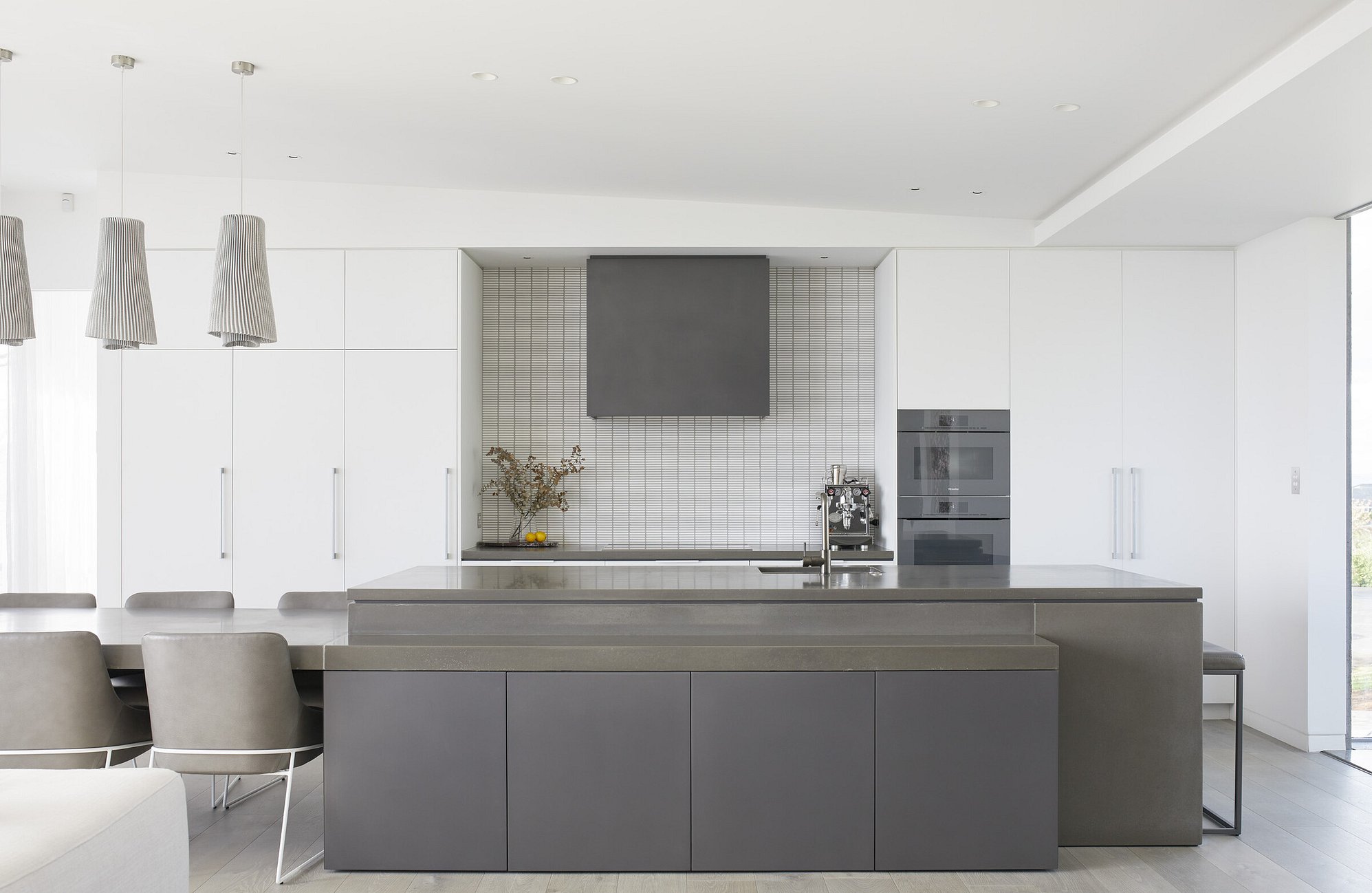 High end kitchen with polished benchtop and crisp white cabinetry
