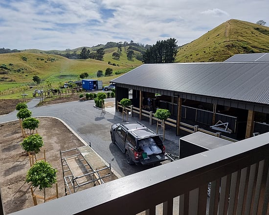 A view from the deck of a barn with integrated stables and apartment, looking down onto the stables