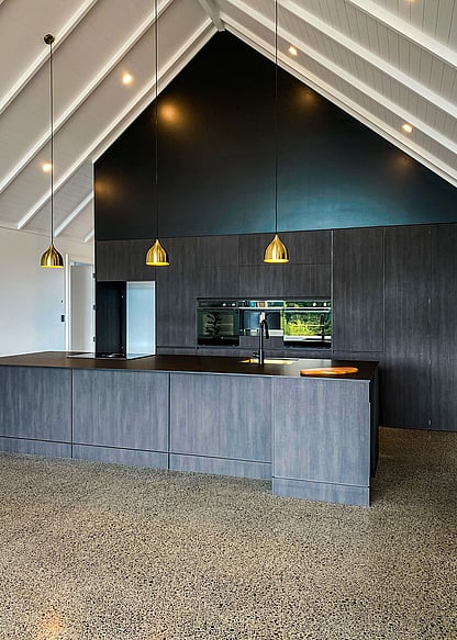 Dark kitchen with metallic pendants