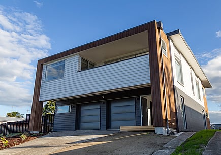 New home renovation in Papamoa by Local Builders, Straight Up Builders Tauranga. The image shows the completed property with enclosed deck area, new roof, new joinery, and new cladding.