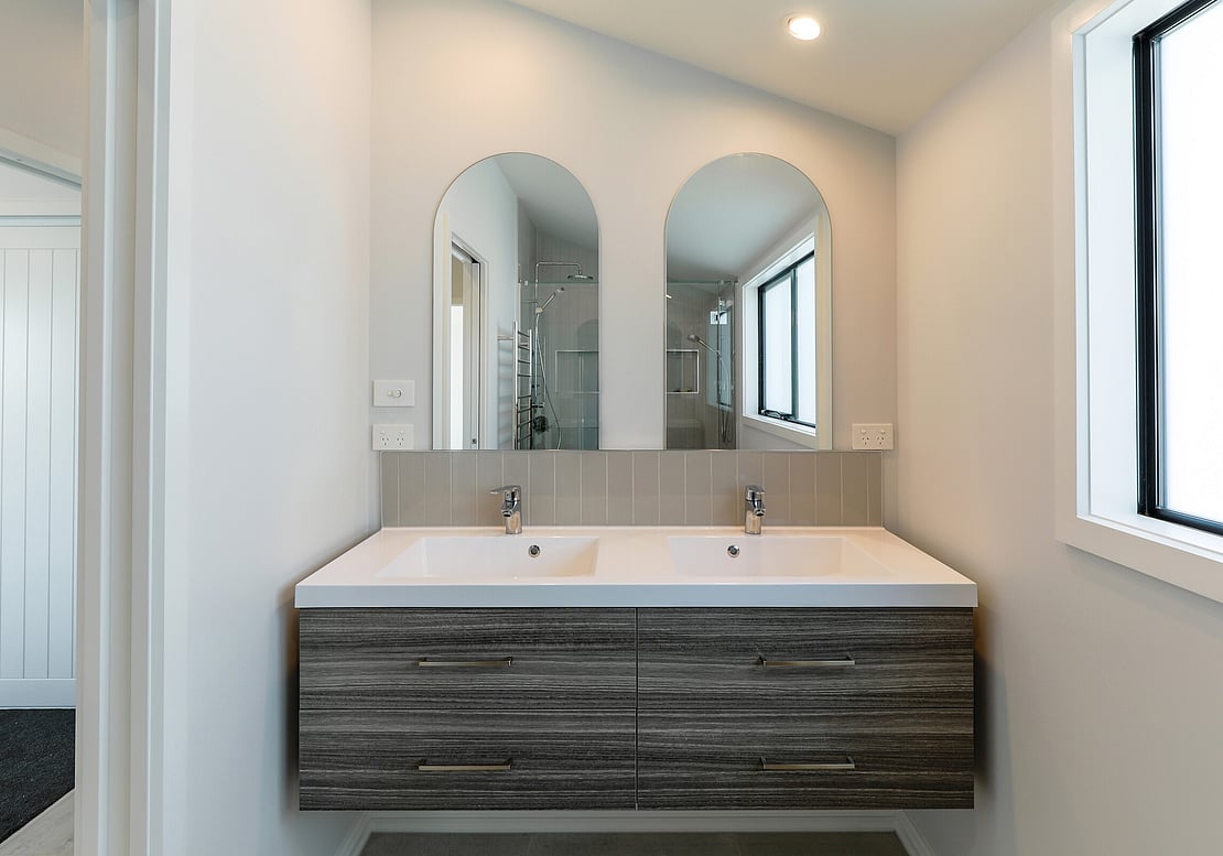 The image shows a new double sink and vanity, along with a double mirror, in this new bathroom fitout in Papamoa. 
