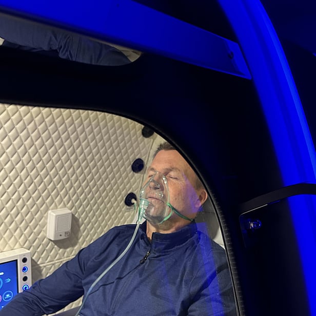 Man receiving hyperbaric oxygen therapy inside a medical-grade chamber at our Auckland clinic