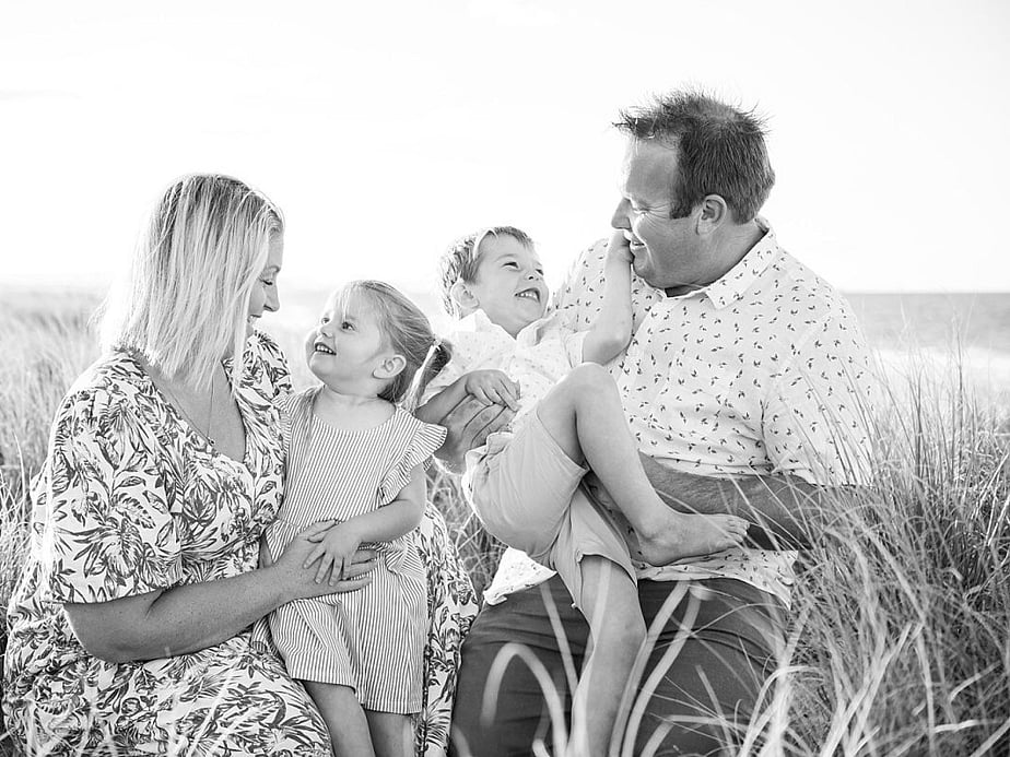 Family of four playing tickle monsters during family photoshoot in Black and White