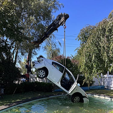 Car being lifted by Williams salvage from a swimming pool
