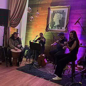 Erica and a band playing live at an event.