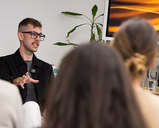 Jaydan Salzke from Rewiring Aotearoa speaks to Kiwis in Climate members at the 2025 Auckland event, an electric kōrero 