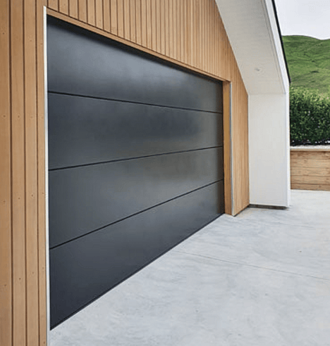 black sectional residential garage door with cedar board surround