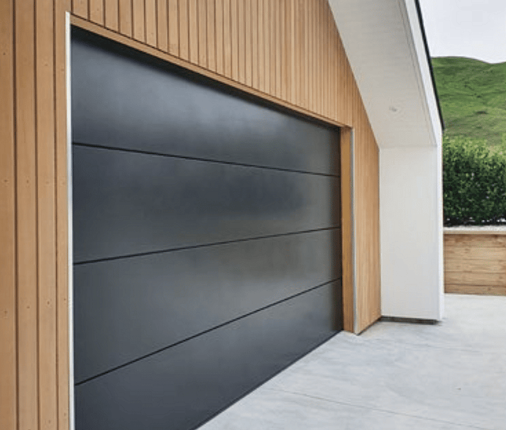 black sectional residential garage door with cedar board surround