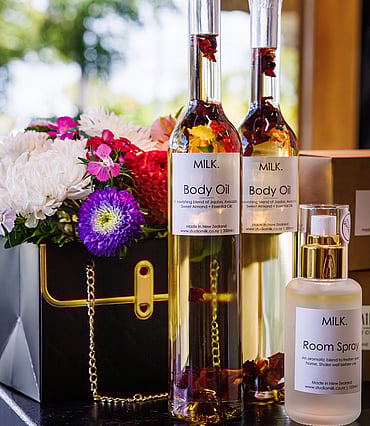An arrangement of flowers and body oil in glass bottles