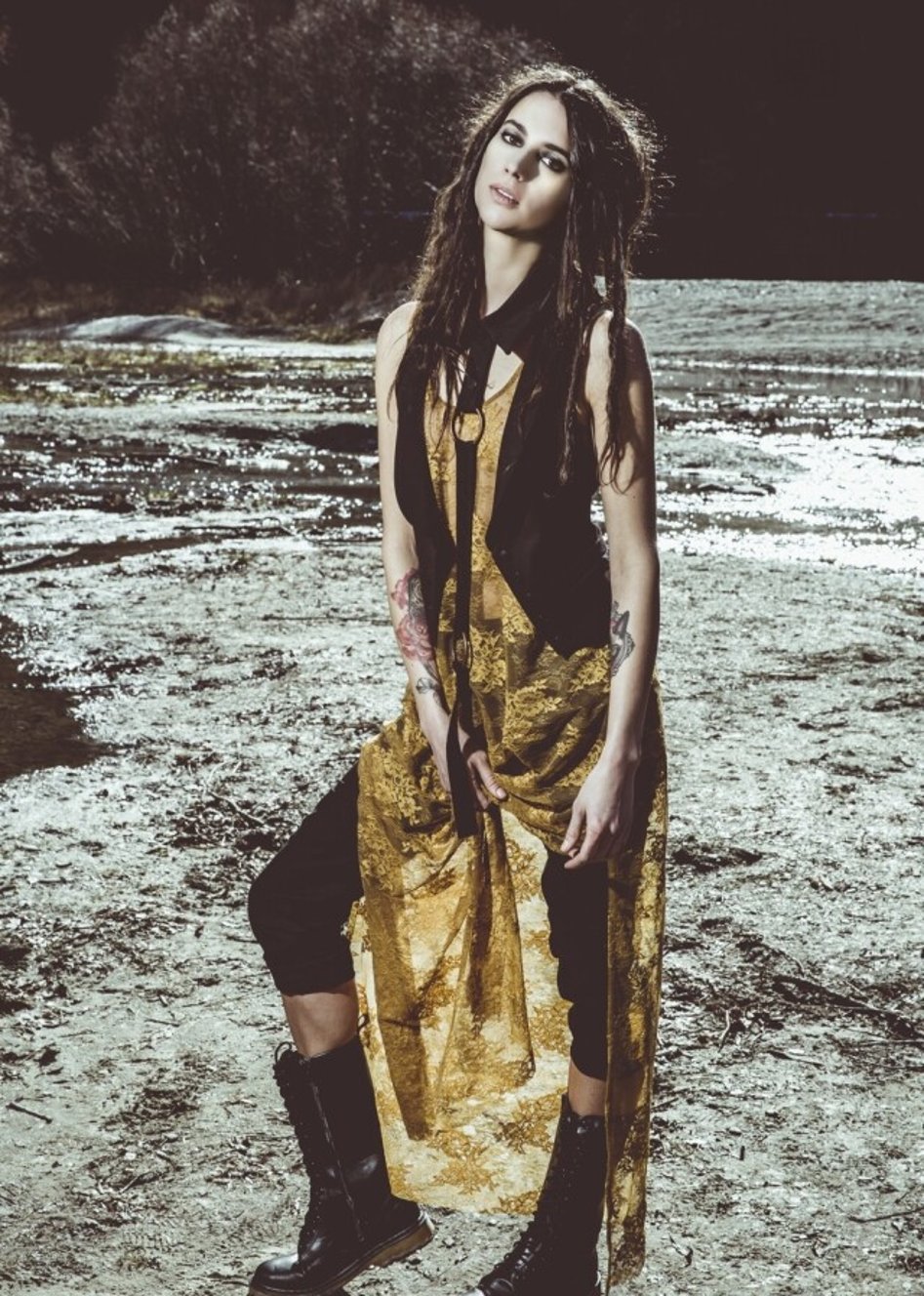 A model wearing a yellow dress and waistcoat designed by Jane Sutherland, photographed at Arrow River, Arrowtown.