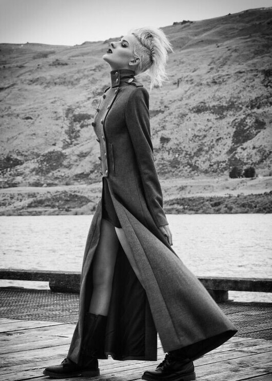A model wearing a long grey military style coat created by Jane Sutherland. Photographed on a wharf at Kingston.