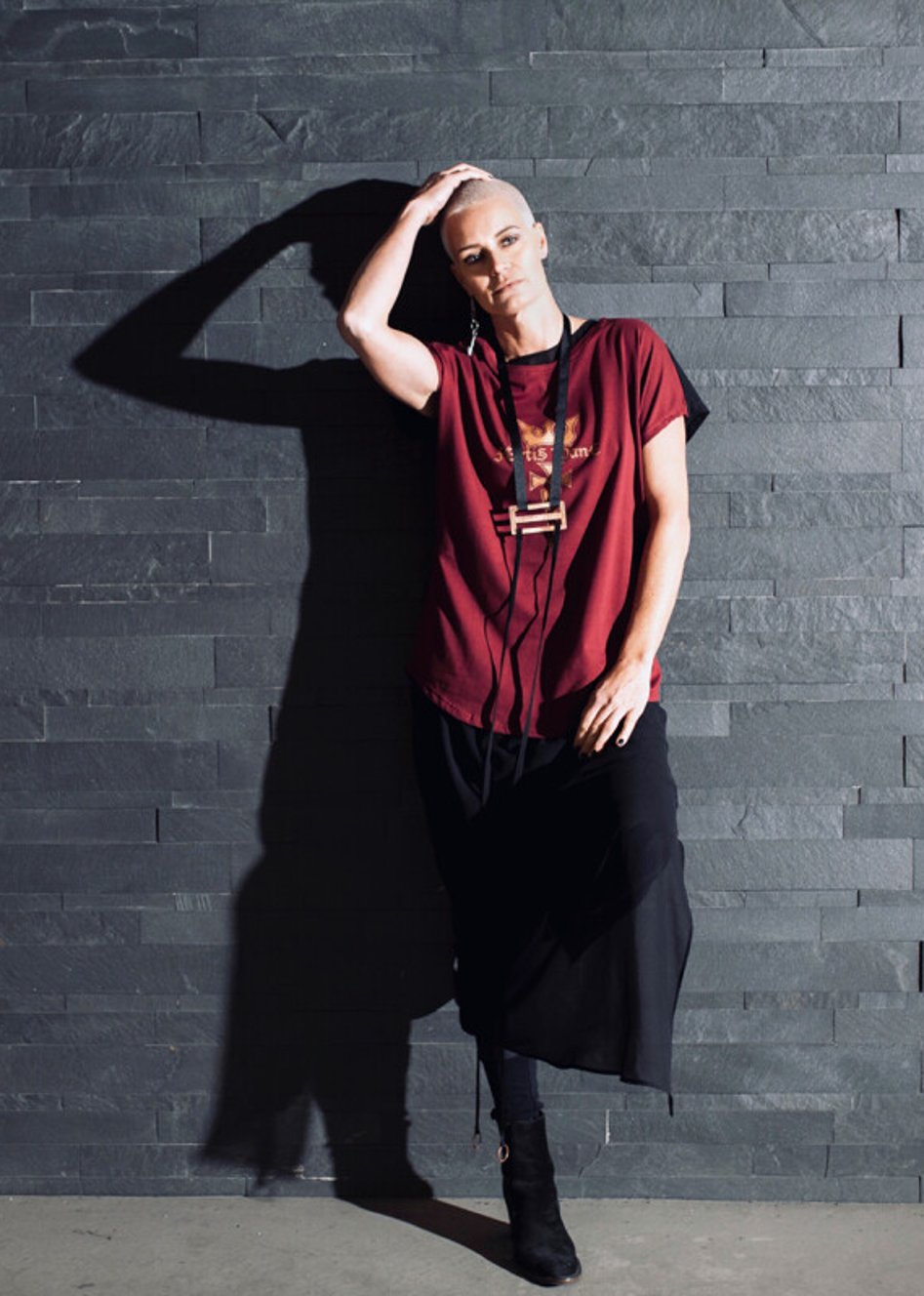 A model wearing a red tee with handmade jewellery designed and created by Jane Sutherland. Photographed at Glenorchy, Queenstown.