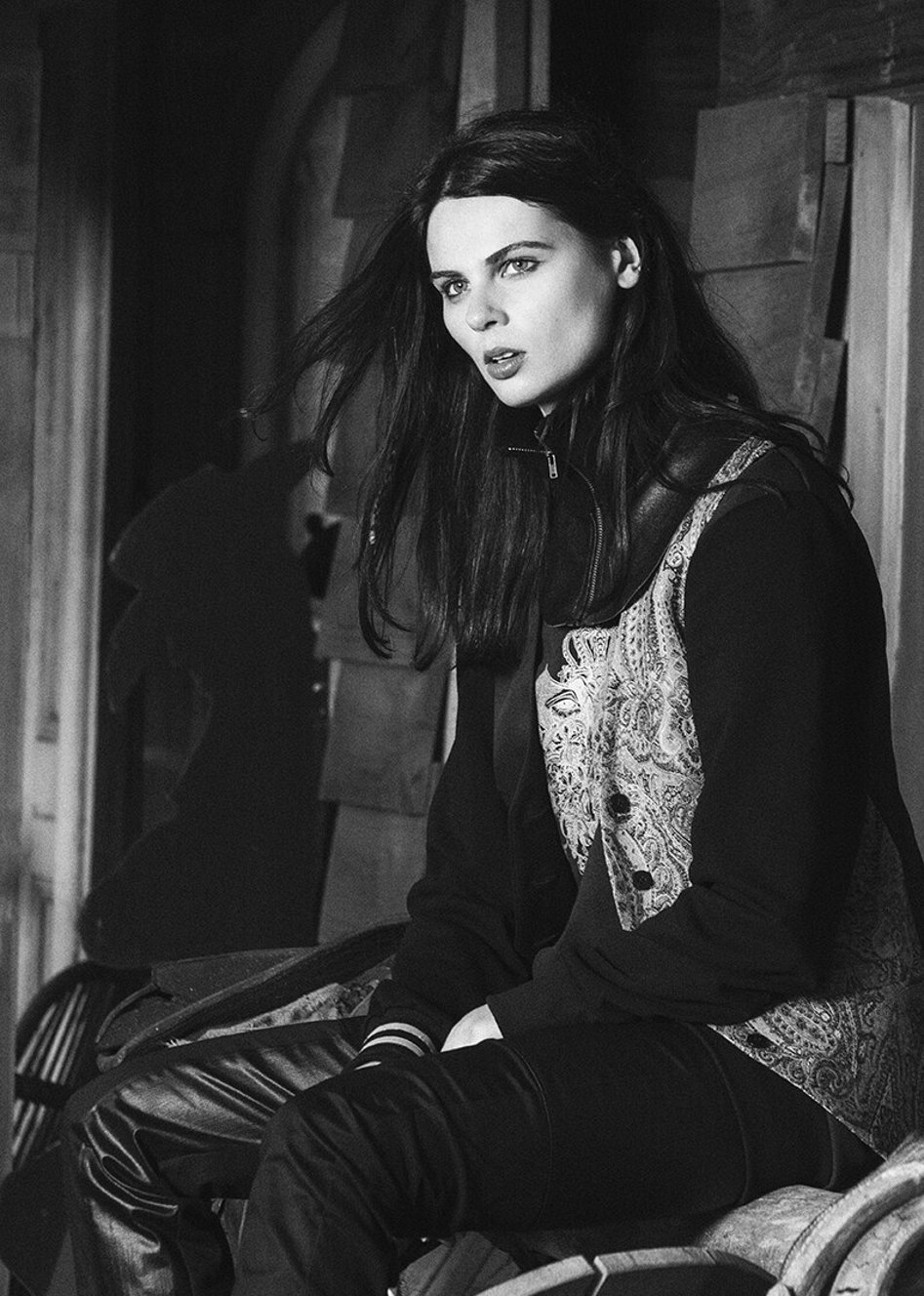 A model sitting while wearing a garment designed and created by Jane Sutherland. Photographed at Gibbston, Queenstown.