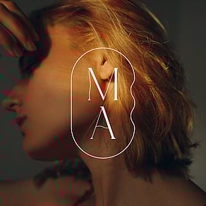 Marnie Aesthetics monogram logo over an image of a women's face.