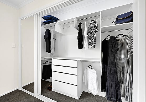 A customised wardrobe space with handing clothes. 