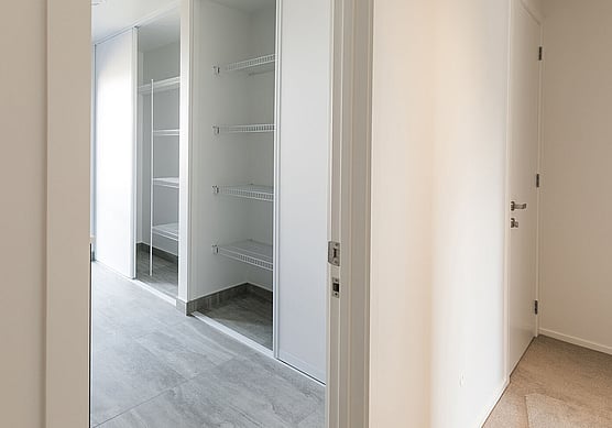 Recessed Laundry Cupboard with Wire Shelving and Sliding Doors.
