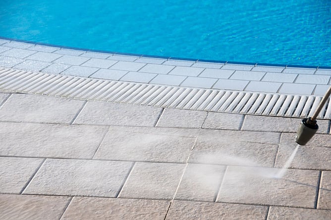 Pool deck pavers being cleaned