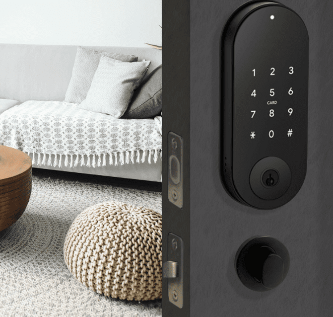The Doorbot Digital Electronic Deadolt installed on a black door with a furnished living room in the background.