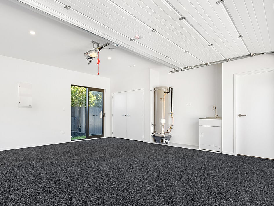 Dark carpeted garage in Eden Construction&rsquo;s new build house on Mountain Road, Mangere Bridge, Auckland.