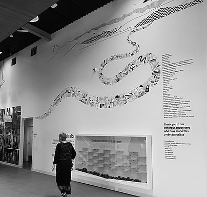 Woman walking past a wall with a large illustration