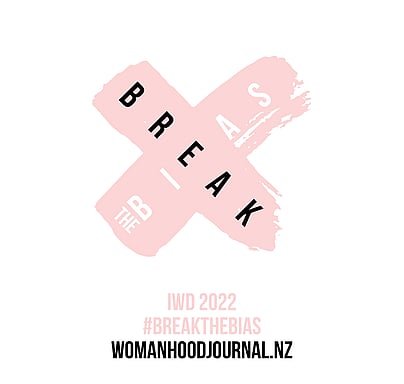 Pink cross with the words 'break the bias' enclosed, the theme for the 2022 International Women's Day