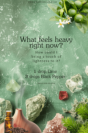 A journal prompt and diffuser blend on a moss and gem background with an essential oil bottle and a diffuser