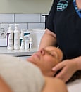 Lira products visible in the background with a lady lying having a treatment with a beauty therapist
