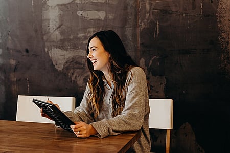 Woman smiling during a meeting, representing GGA's focus on shared success and board efficiency