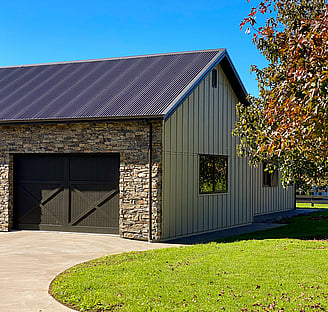 Barn with schist facia barn style garage doors and gable roof