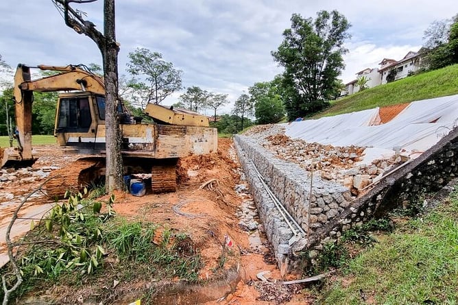 digger working on site drainage with retainig walls 
