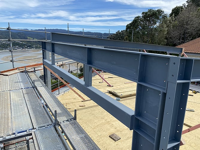 Structural steel frame installation on coastal hillside build Paku Tairua
