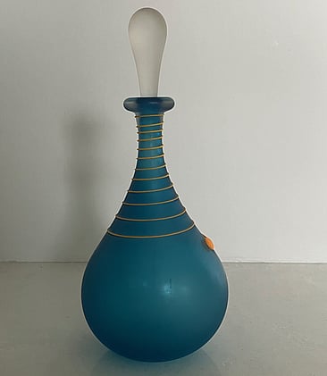 This blue art glass scent bottle has a lovely orange swirl around the neck of the bottle, providing a stunning contrast. It has a long clear stopper. 