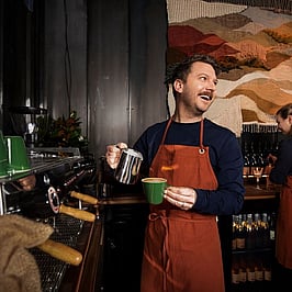 A barista making coffee on the set of a commercial Laura worked on.