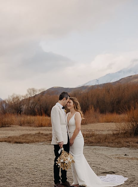 A couple together in a riverbed in Queenstown, brides makeup by Laura at Makemeup.