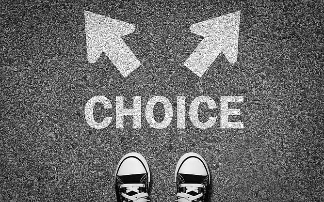 Someone stood on a road needing to choose between going one way or another.