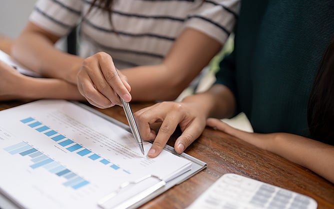 Two people sat at a desk reviewing documents.