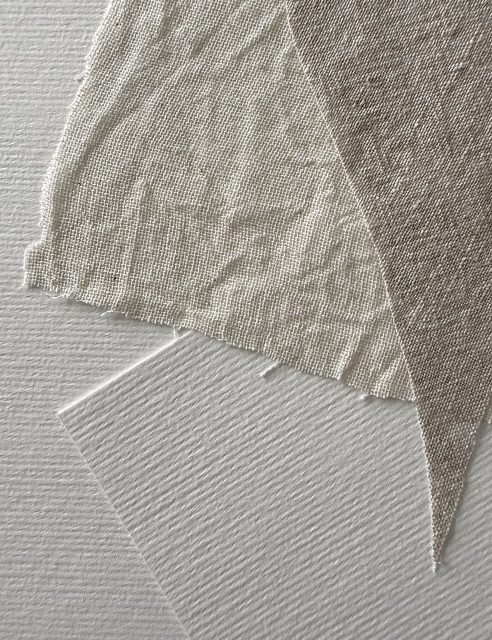 layered linen fabrics on Fabriano paper, showing linen weave, texture and soft frayed edges